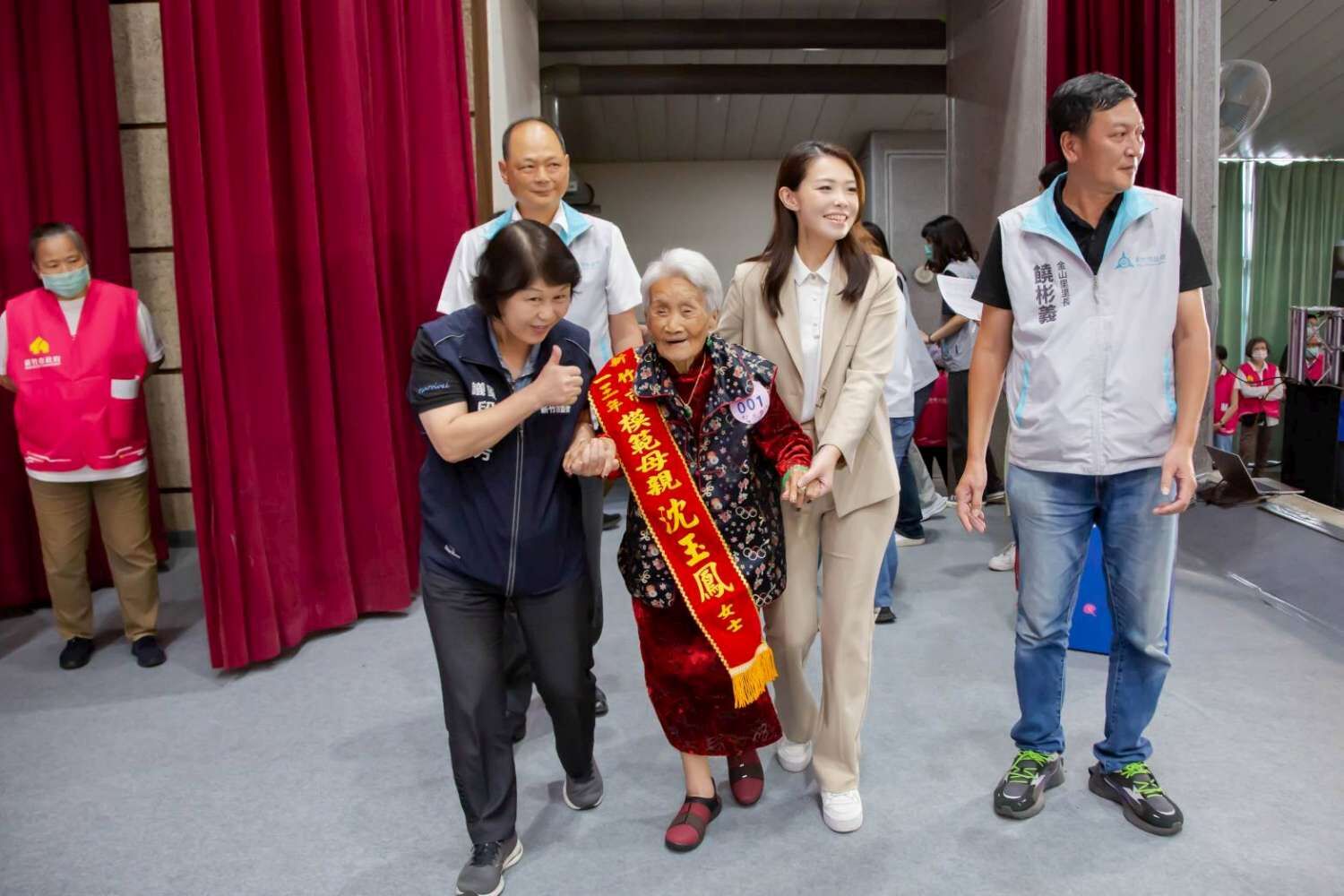 高市長牽著模範母親當日最高齡者102歲的沈玉鳳奶奶到台上。