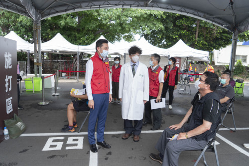 市長與邱國華理事長在疫苗施打站向民眾寒暄。